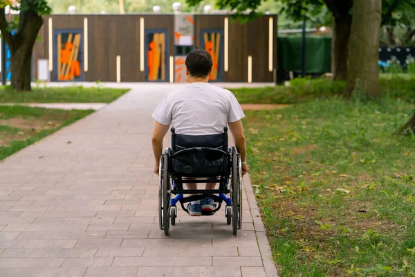 Ένταξη Ένας Άνδρας Αναπηρίες Οδηγεί Ένα Αναπηρικό Καροτσάκι Κατά Μήκος — Φωτογραφία Αρχείου