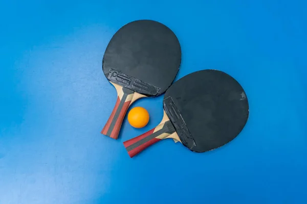 Tennisracketer Oransje Tennisball Ligger Blått Tennisbord Ved Siden Nett Bypark – stockfoto