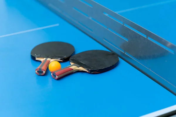 Zwei Tennisschläger Und Ein Orangefarbener Tennisball Liegen Auf Einer Blauen — Stockfoto