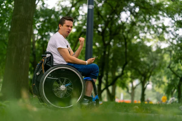 Inclusiveness Happy Man Disabilities Wheelchair Looking Smartphone Holds His Hands — Stock Photo, Image