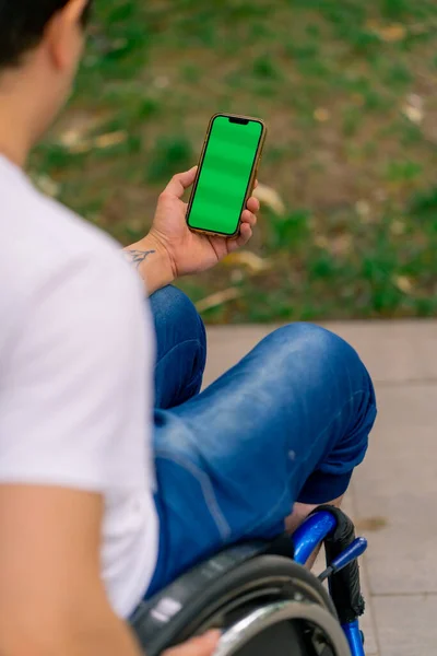 Людина Обмеженими Можливостями Інвалідному Візку Тримає Телефон Відкритим Зеленим Екраном — стокове фото