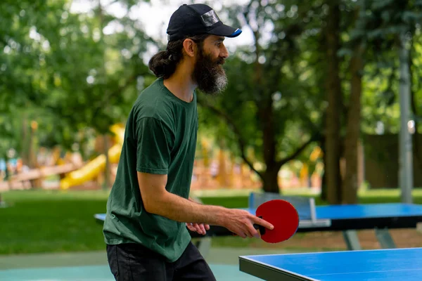 Başlık Takan Raket Tutan Yaşlı Bir Adam Şehir Parkında Ağaçlara — Stok fotoğraf