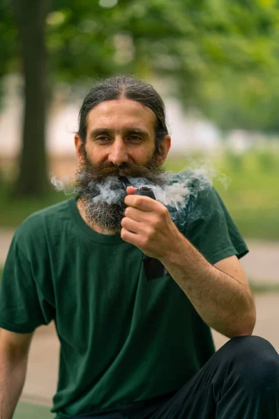 Older Man Long Hair Gray Beard Smokes Pipe City Park — Stock Photo, Image