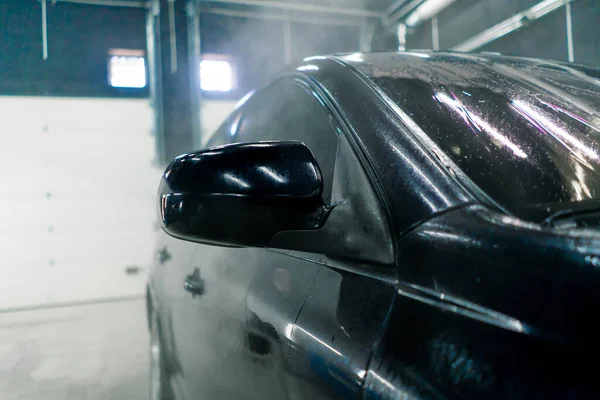 高圧洗浄時のラグジュアリーブラックカーの屋根とガラスのクローズアップ — ストック写真