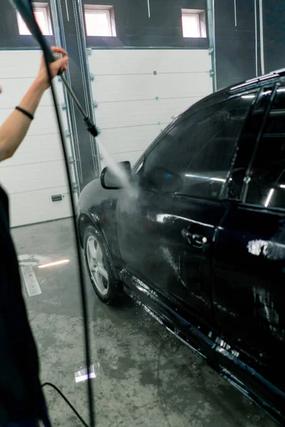 Pracownik Myjni Myje Czarny Luksusowy Samochód Myjką Wysokociśnieniową Myjni Samochodowej — Zdjęcie stockowe