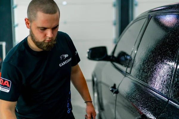 Een Mannelijke Carwash Medewerker Carwash Wasmiddel Toe Een Zwarte Luxe — Stockfoto