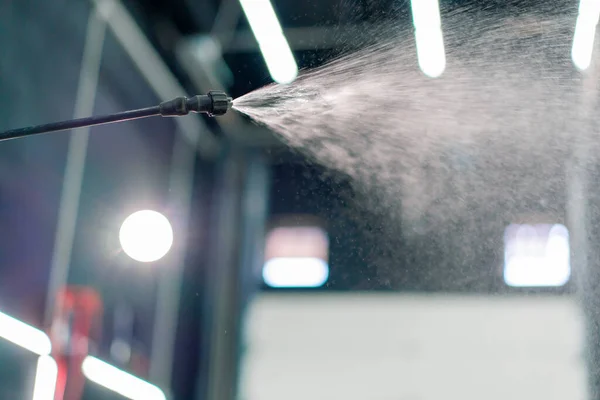 Close-up of the moment of spraying water from the sprayer during car washing