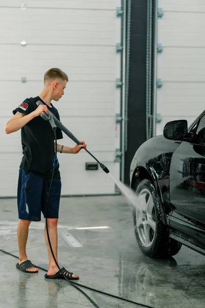 Een Mannelijke Carwash Medewerker Wast Een Zwarte Luxe Auto Met — Stockfoto