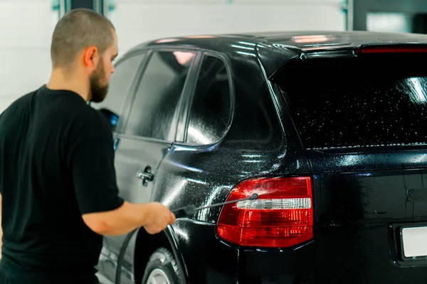 Ένας Άνδρας Υπάλληλος Πλυντηρίου Αυτοκινήτων Εφαρμόζει Απορρυπαντικό Πλυντηρίου Αυτοκινήτων Ένα — Φωτογραφία Αρχείου
