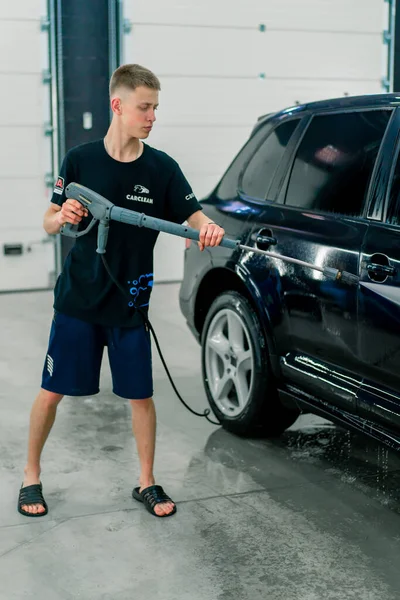 Een Mannelijke Carwash Medewerker Wast Een Zwarte Luxe Auto Met — Stockfoto