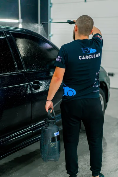 Een Mannelijke Carwash Medewerker Carwash Wasmiddel Toe Een Zwarte Luxe — Stockfoto