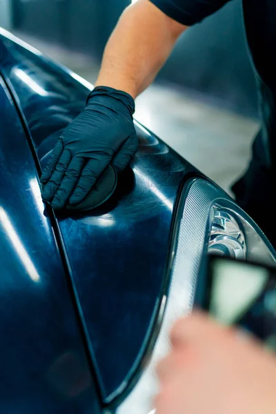 Zbliżenie Pracownika Myjni Samochodowej Czarnych Rękawiczkach Polerującego Maskę Reflektor Luksusowego — Zdjęcie stockowe