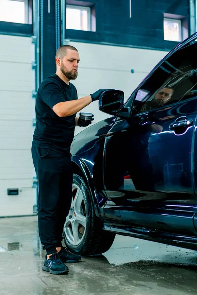 Fókuszált Férfi Autómosó Fekete Kesztyűben Fényesíti Tükör Egy Luxus Kék — Stock Fotó
