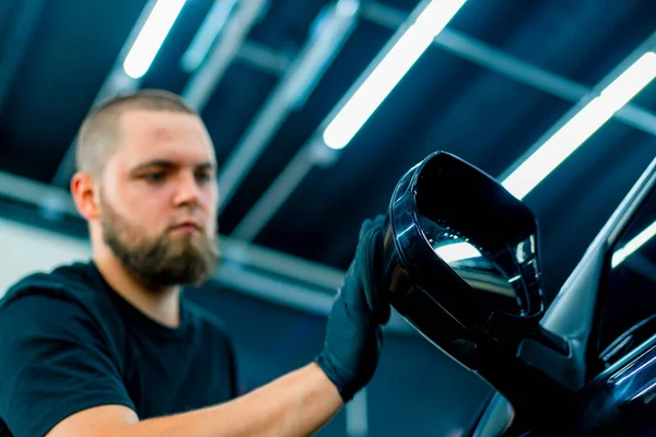 黒い手袋に焦点を当てた男性用洗車労働者は スポンジカーケアのコンセプトを使用して高級ブルーカーの鏡を磨きます — ストック写真