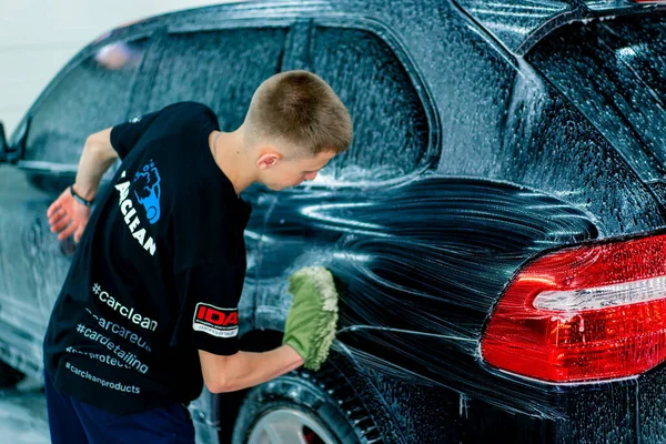 Een Mannelijke Carwash Medewerker Gebruikt Een Groene Washandje Zwarte Luxe — Stockfoto