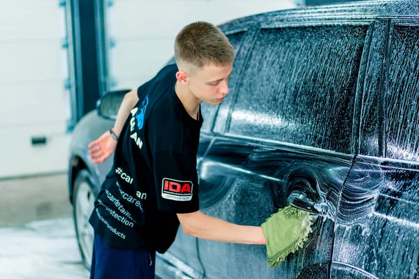 Een Mannelijke Carwash Medewerker Gebruikt Een Groene Washandje Zwarte Luxe — Stockfoto