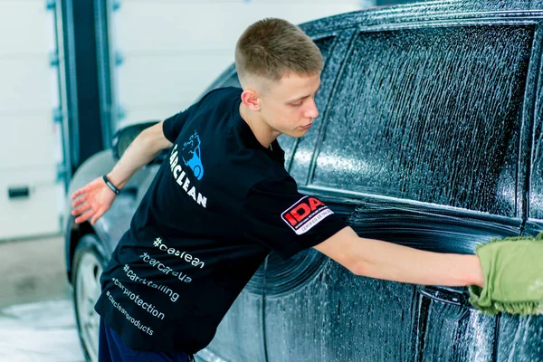 Een Mannelijke Carwash Medewerker Gebruikt Een Groene Washandje Zwarte Luxe — Stockfoto