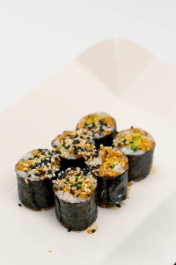 Beyaz arka planda suşi teslimat kutusunda soya soslu avokado ile maki rulosunun yakın plan çekimi.