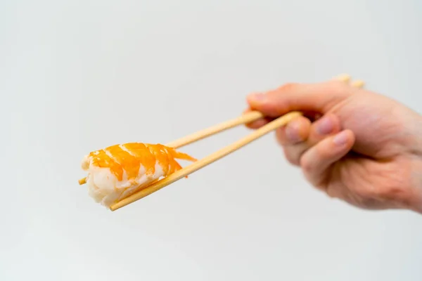 Close Mão Homem Com Pauzinhos Segurando Sushi Camarão Fundo Branco — Fotografia de Stock