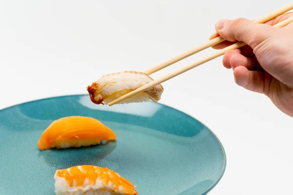 Primer Plano Una Mano Masculina Usando Palillos Para Tomar Sushi —  Fotos de Stock