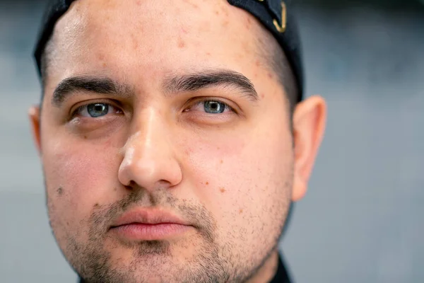 stock image Portrait of a serious male sushi maker in a cap on the background of professional kitchen