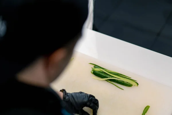 Close Van Een Sushi Maker Handschoenen Snijden Van Een Komkommer — Stockfoto