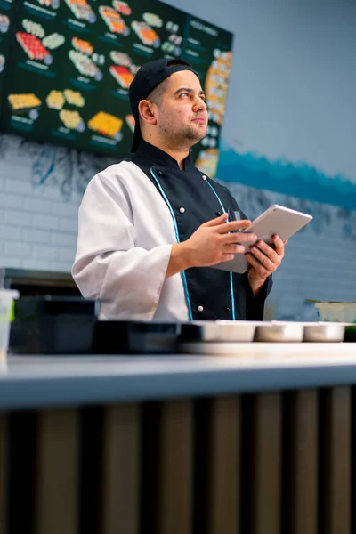 Chef Sushi Réfléchi Avec Tablette Dans Ses Mains Près Table — Photo