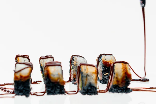 カリフォルニアのクローズアップ 黒米ウナギと美しいブループレートのアンギソースで乾燥したロール 寿司とアジア料理の愛のコンセプト — ストック写真