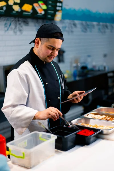 Chef Sushi Reflexivo Con Tableta Las Manos Cerca Mesa Cocina —  Fotos de Stock