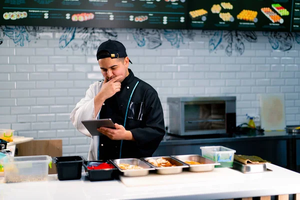 Chef Sushi Réfléchi Avec Tablette Dans Ses Mains Près Table — Photo
