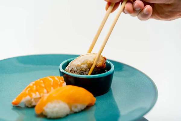 箸を使って手を閉じ 醤油のサーモンとエビ寿司のプレートからウナギ寿司を拾い — ストック写真