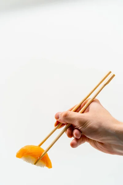 Close Pauzinhos Mão Homem Segurando Sushi Salmão Fundo Branco — Fotografia de Stock