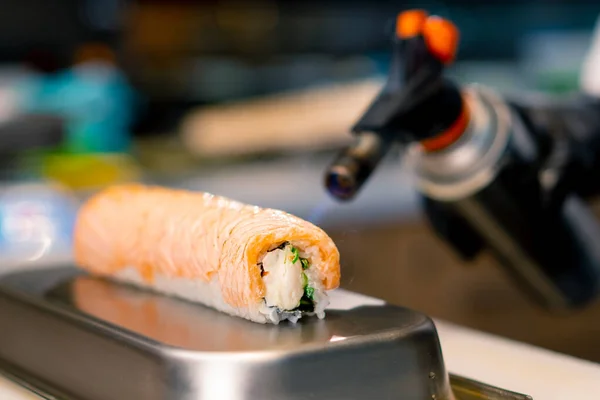 Close Sushi Kok Med Gasbrænder Hånden Brændende Laks Philadelphia Rulle - Stock-foto