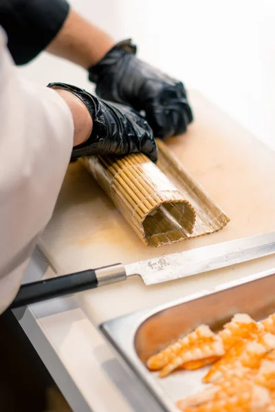 Primer Plano Fabricante Sushi Con Guantes Negros Envolviendo Rollo California —  Fotos de Stock