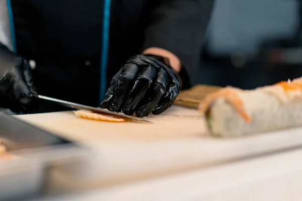 Крупный План Производителя Суши Черных Перчатках Разрезающего Филе Креветок Ножом — стоковое фото