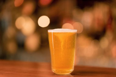 Bar 'daki ahşap tezgahın üzerinde bir bardak birayı kapat. Bira ve alkollü içeceklere duyulan sevgi.