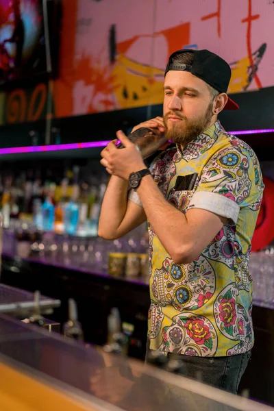 金属製のシェーカーでアルコールを混合するプロの若いバーテンダー バーでクラブでカクテルを作るプロセス — ストック写真