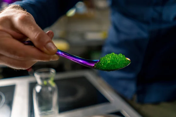 Close Chef Professional Kitchen Pouring Green Molecular Caviar Grains Spoon — Stock Photo, Image