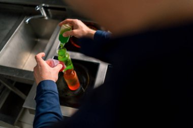 Profesyonel bir mutfak deneyinde bir şef çok renkli moleküler havyar tanelerini kaplara yakın çekim suyla ekleyerek