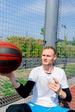 Basketbol oyuncusu, basketbol serbest stil becerilerini göstermek için parmağında basketbol topunu döndürüyor.