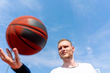 Basketbol oyuncusu, basketbol serbest stil becerilerini göstermek için parmağında basketbol topunu döndürüyor.