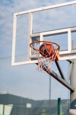 Basketbol topunun, basketbol ve spor yapma sevgisi konseptine vurduğu yakın çekim bir basketbol potası.