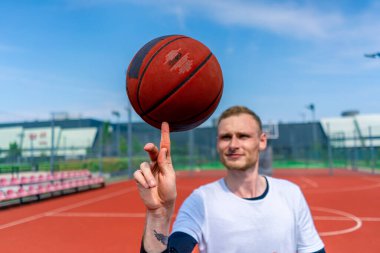 Basketbol oyuncusu, basketbol serbest stil becerilerini göstermek için parmağında basketbol topunu döndürüyor.