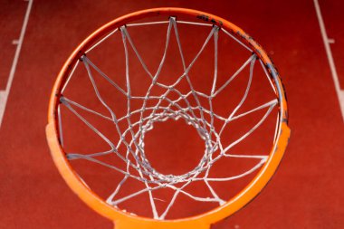 Basketbol ringinin yakın planında uzun boylu bir basketbolcu topu basketbol maçına hayran olma konseptinin altından fırlatıyor.