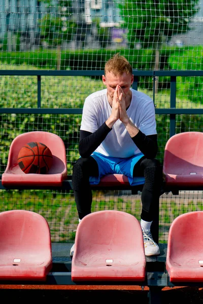 Großer Frustrierter Basketballspieler Auf Der Tribüne Eines Basketballfeldes Mit Ball — Stockfoto