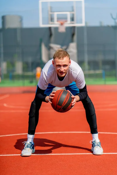 在公园的篮球场上 一个高个子篮球运动员手里拿着球的画像 — 图库照片