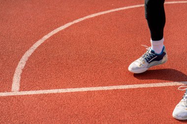 Uzun boylu basketbol oyuncusu parktaki basketbol sahasında top sürme yeteneğini gösteriyor.