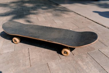 Parktaki yolda uzanan kaykaya yakın plan adrenalin tutkusu ve kaykay sevgisi kavramı.