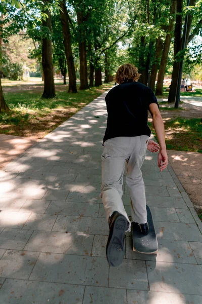 Mladý Kluk Bruslař Jezdí Skateboardu Cestě Městského Parku Pozadí Stromů — Stock fotografie