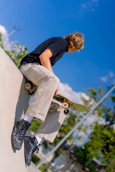 Young Guy Skateboarder Long Hair Sits His Skateboard Edge Skate — Stock Photo, Image